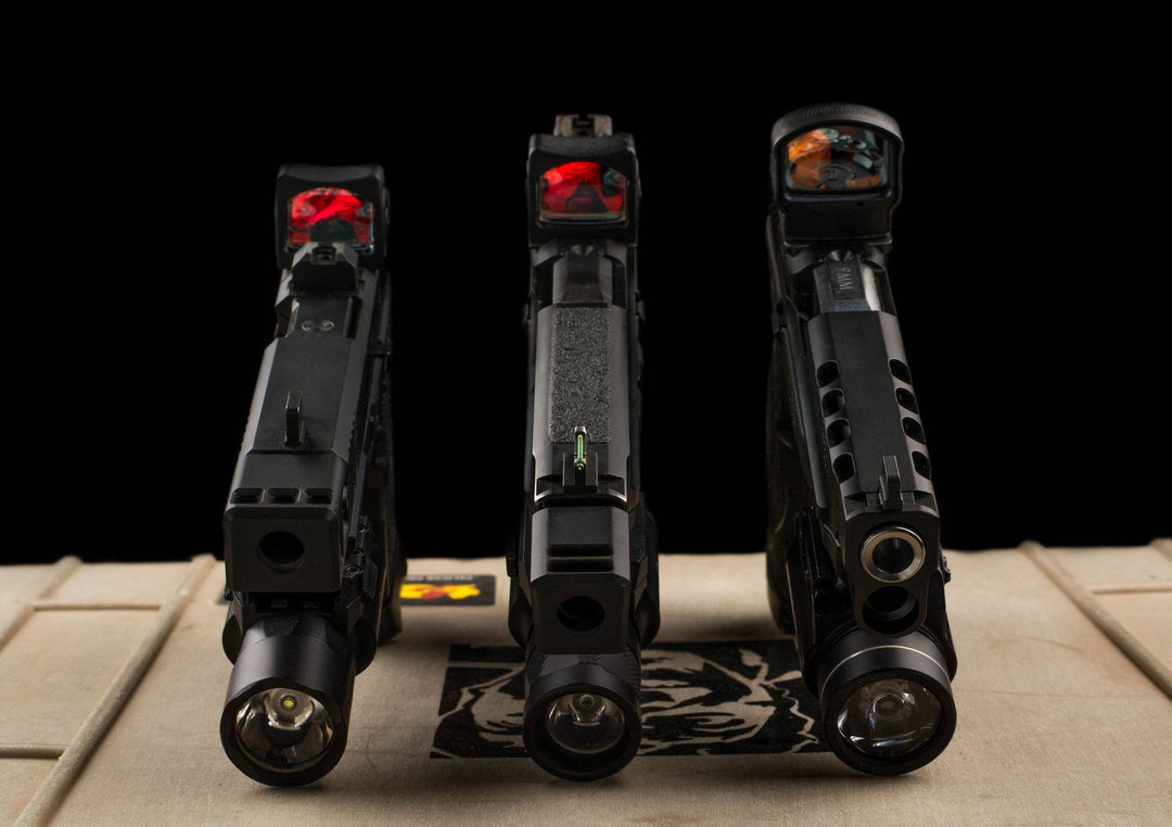 Three handguns demonstrating different red dot sights.