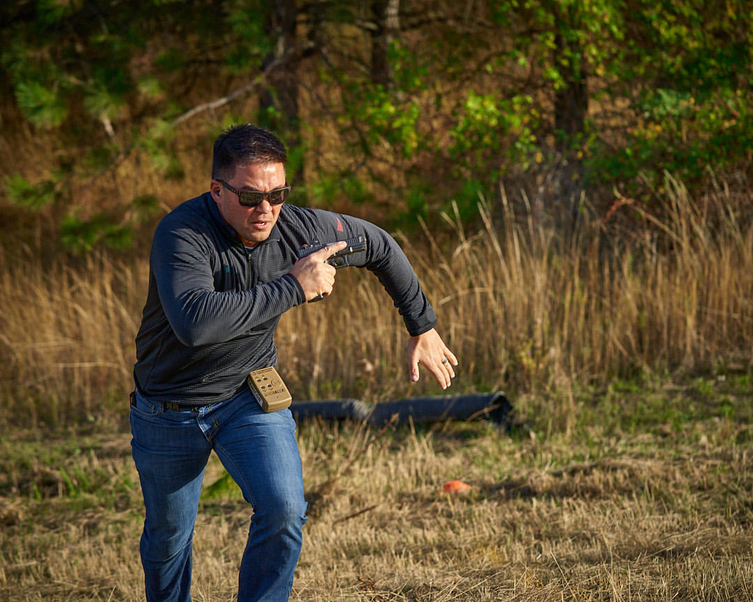 Man running between targets during an outdoor shooting range or training centre.