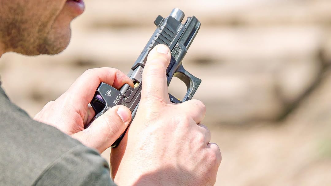 Man demonstrating how to check the chamber of a handgun for a loaded round.