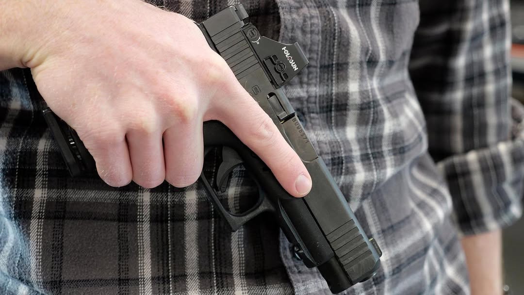 Man demonstrating safe finger placement when holding a handgun.