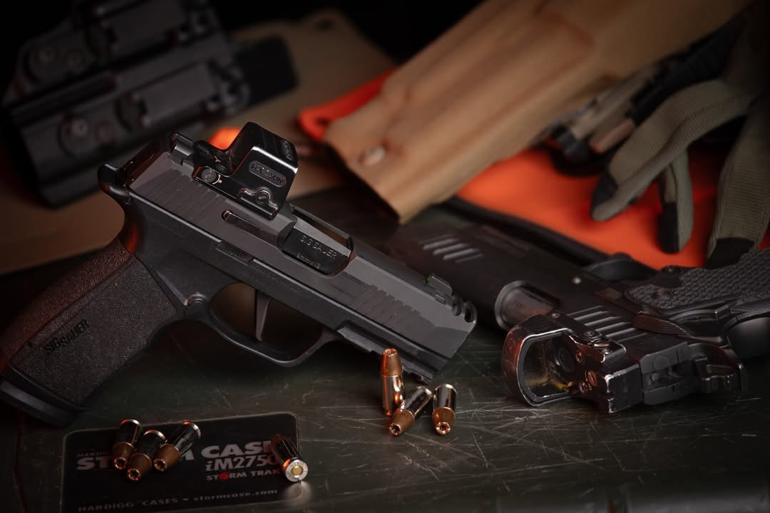 Handguns along with bullets on a table for demonstration purposes.