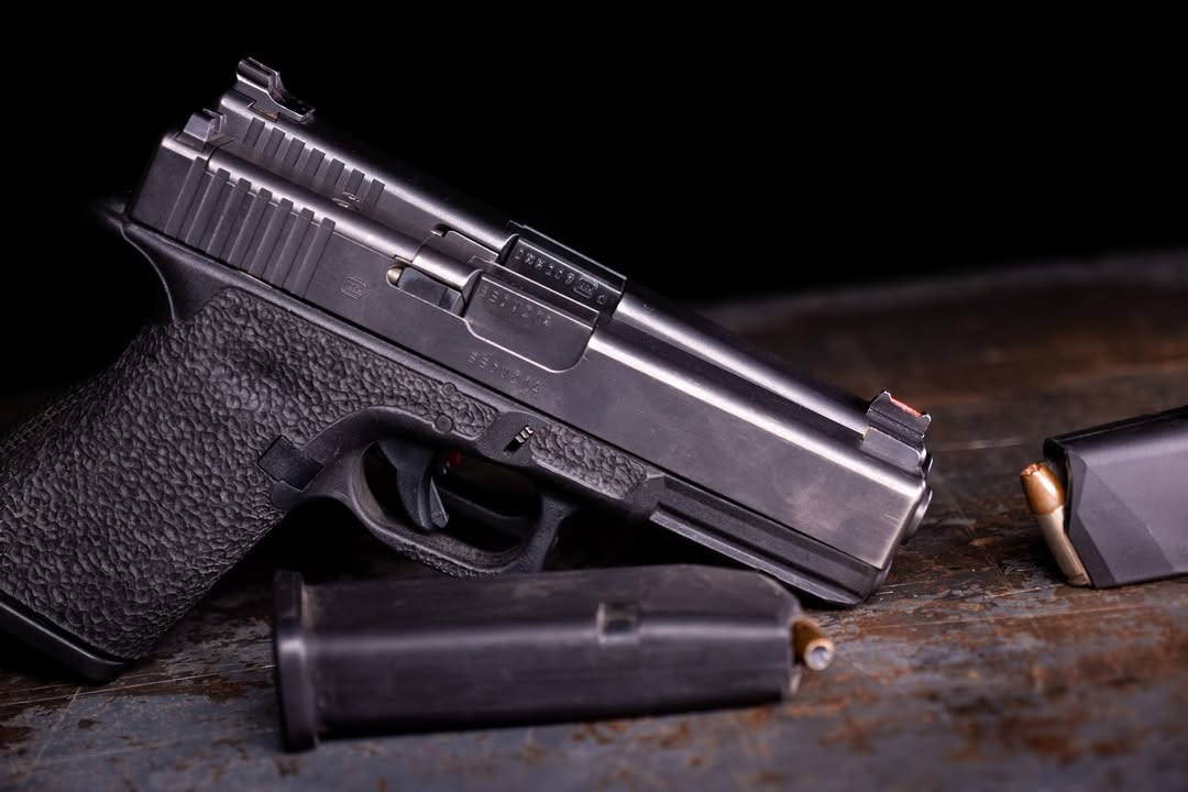 Handgun and loaded magazine on a general background for demonstration purposes.